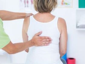 Paciente com queixas de dores nas costas na região das omoplatas sendo examinado por um médico